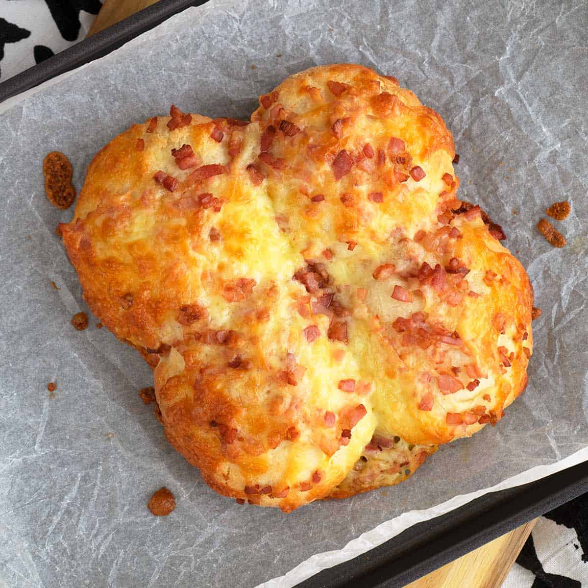 A tray of bacon and cheese biscuits on a baking sheet.