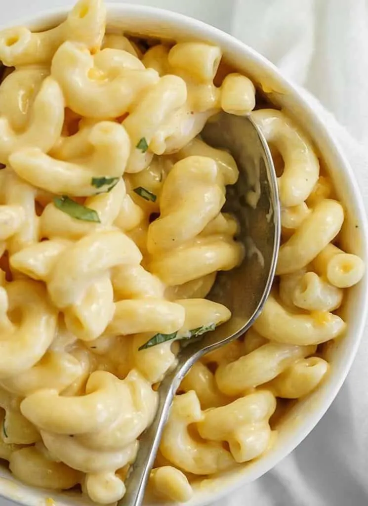 No boil macaroni and cheese in a white bowl with a spoon.