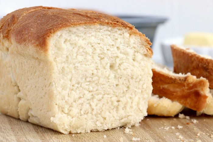 A loaf of no-knead white bread on a cutting board.
