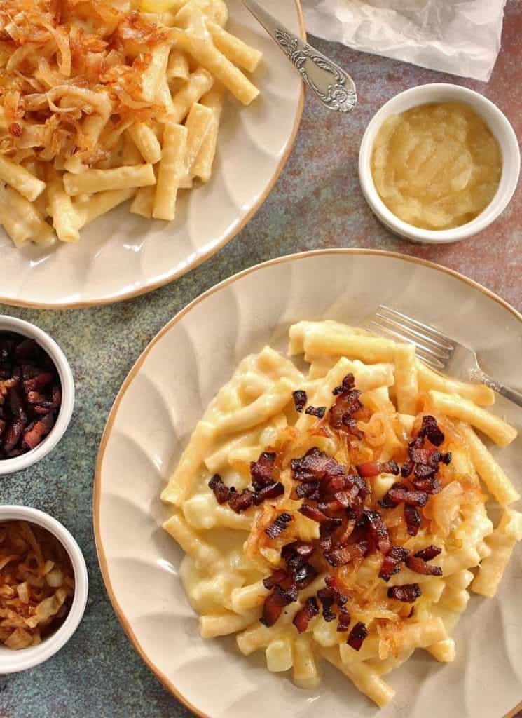 Two plates of mac and cheese with onions, showcasing variations.