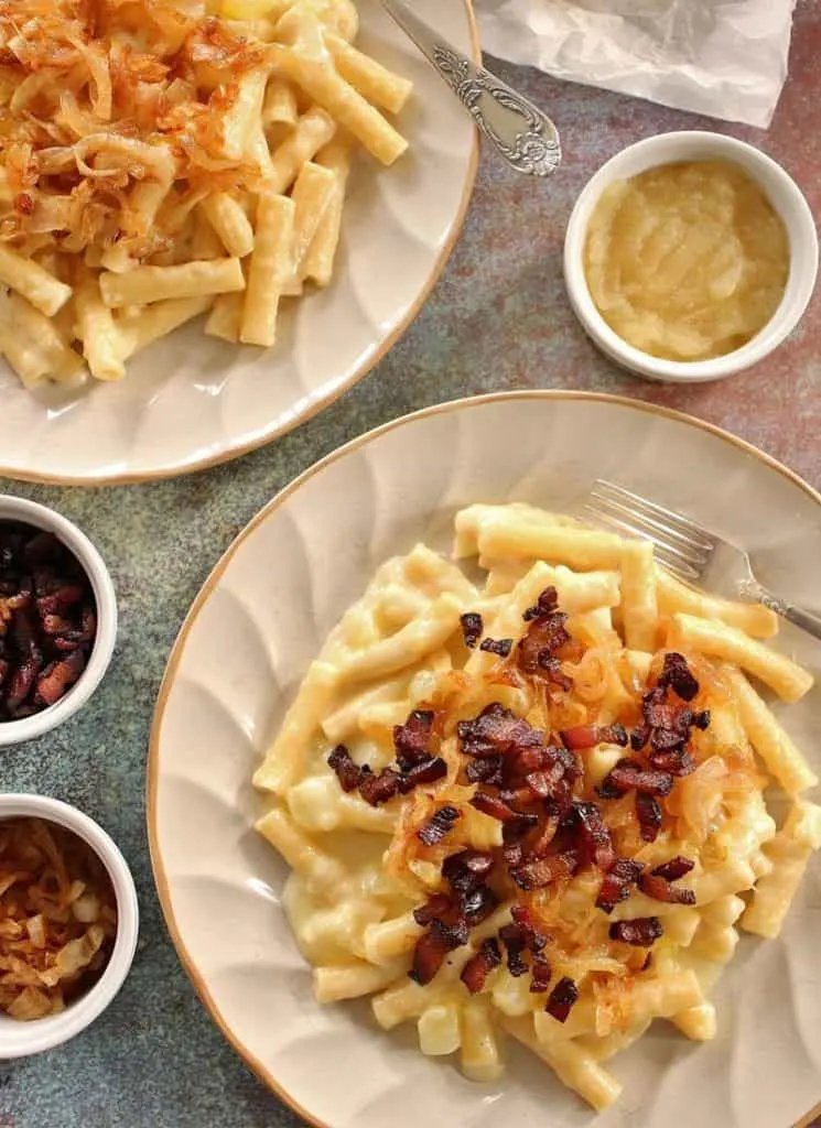 Two plates of mac and cheese with onions, showcasing variations.