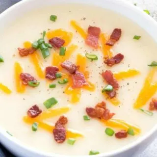 Two bowls of potato soup with bacon and chives.