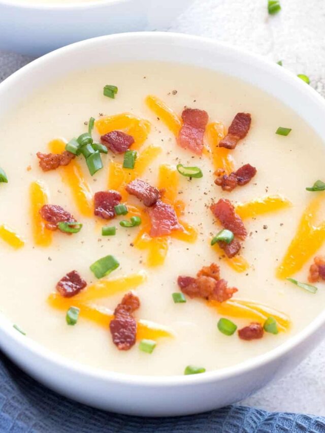 Two bowls of potato soup with bacon and chives.