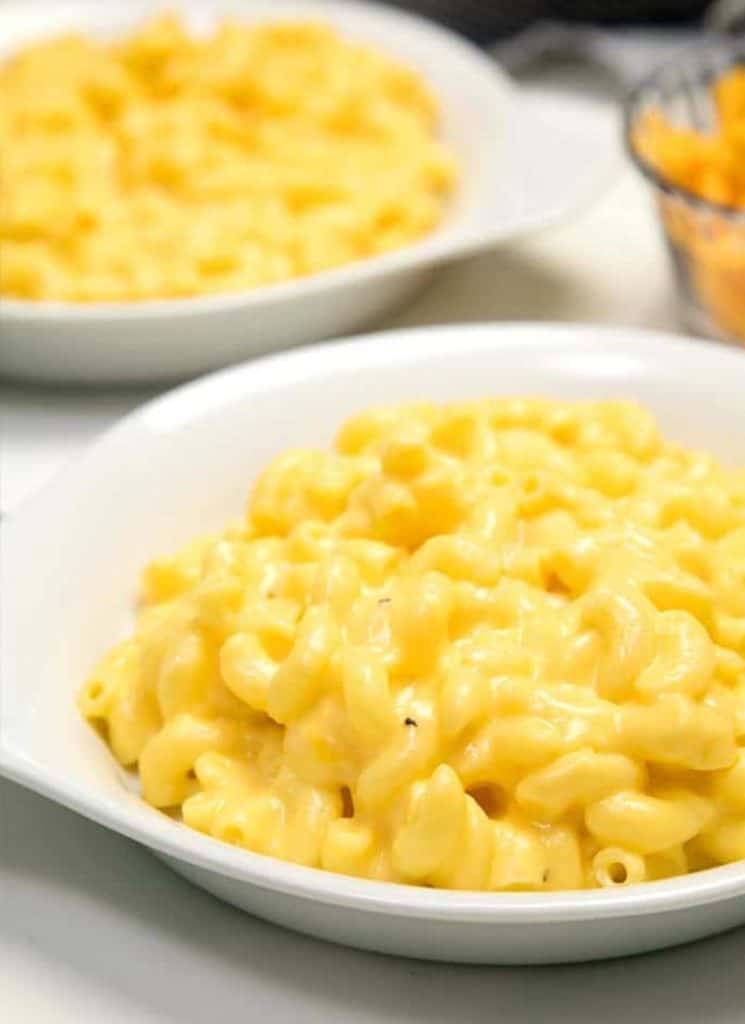 Two bowls of gluten-free stovetop macaroni and cheese on a table.