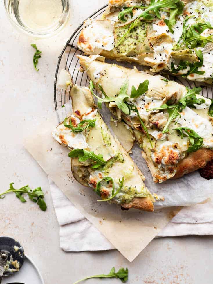 A pizza with cheese and arugula.