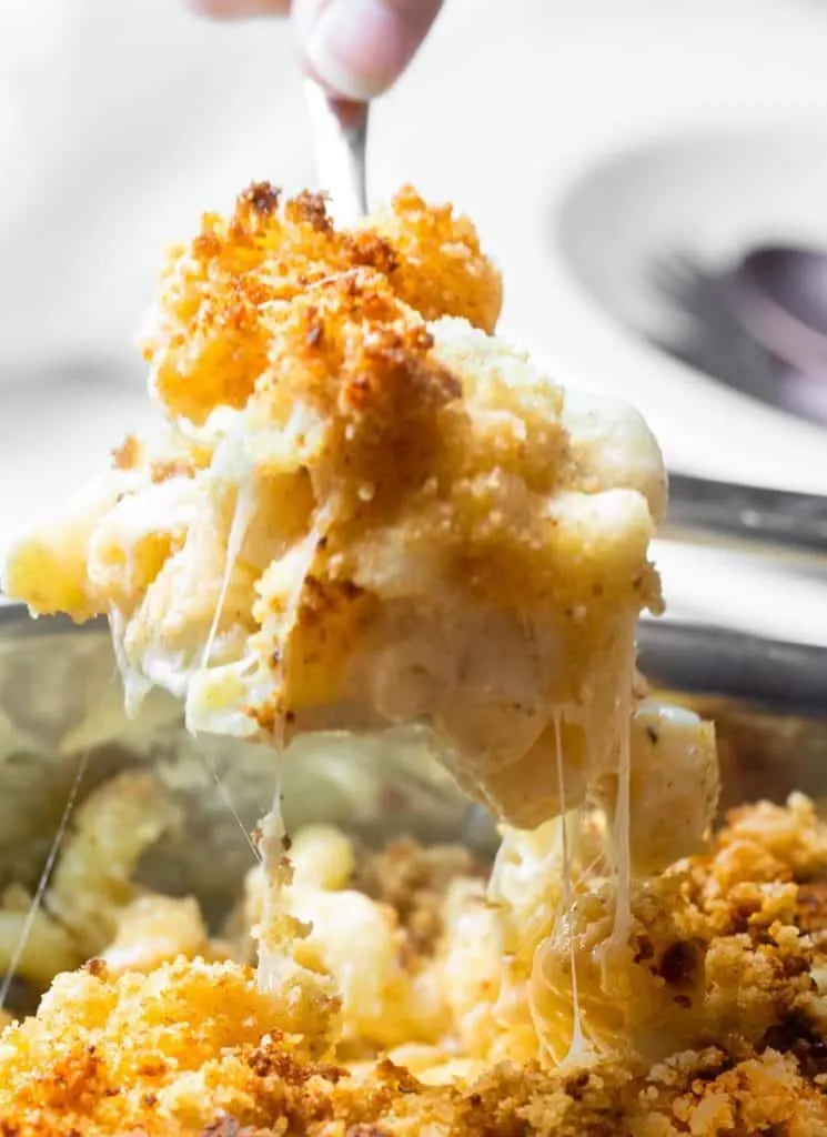 A fork is being used to pick up a dish of southern baked macaroni and cheese.