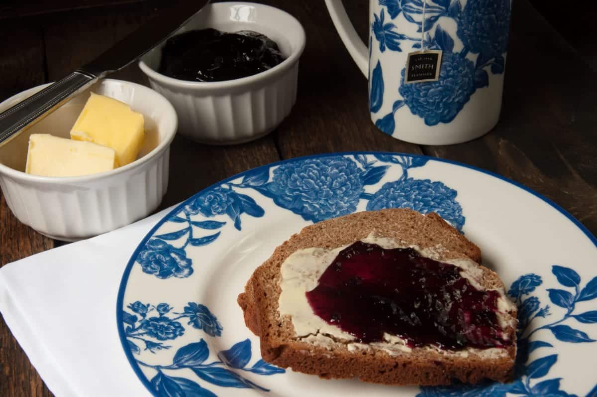 A plate of yeast-free bread with jam and butter on it.