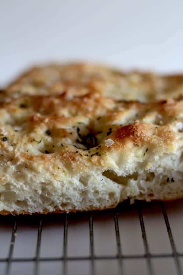 A piece of bread, freshly baked and placed on a cooling rack.