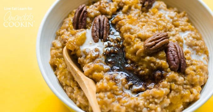 A bowl of butternut squash oatmeal with wooden spoon.