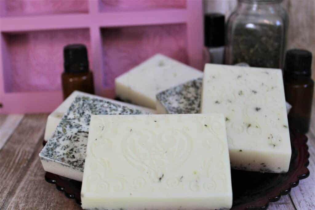 Soap bars next to brown essential oil bottles.