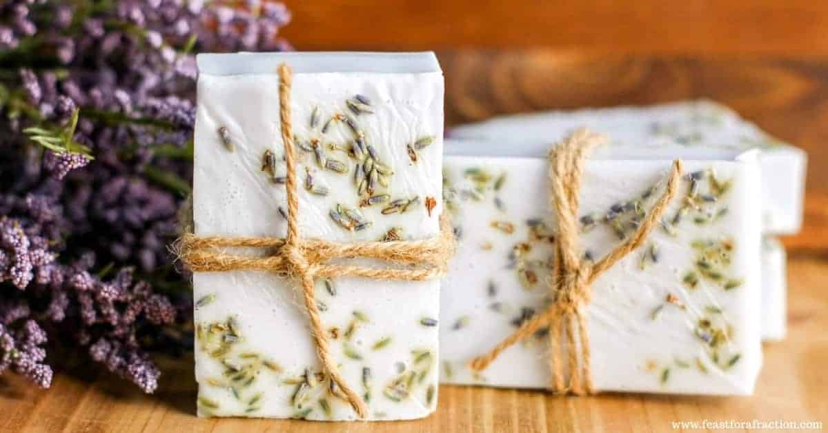 Lavender soap bars tied using a twine next to purple flowers.