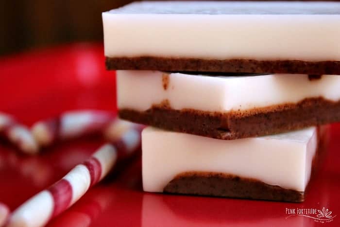 A stack of white and brown-layered bar soap next to a candy cane.