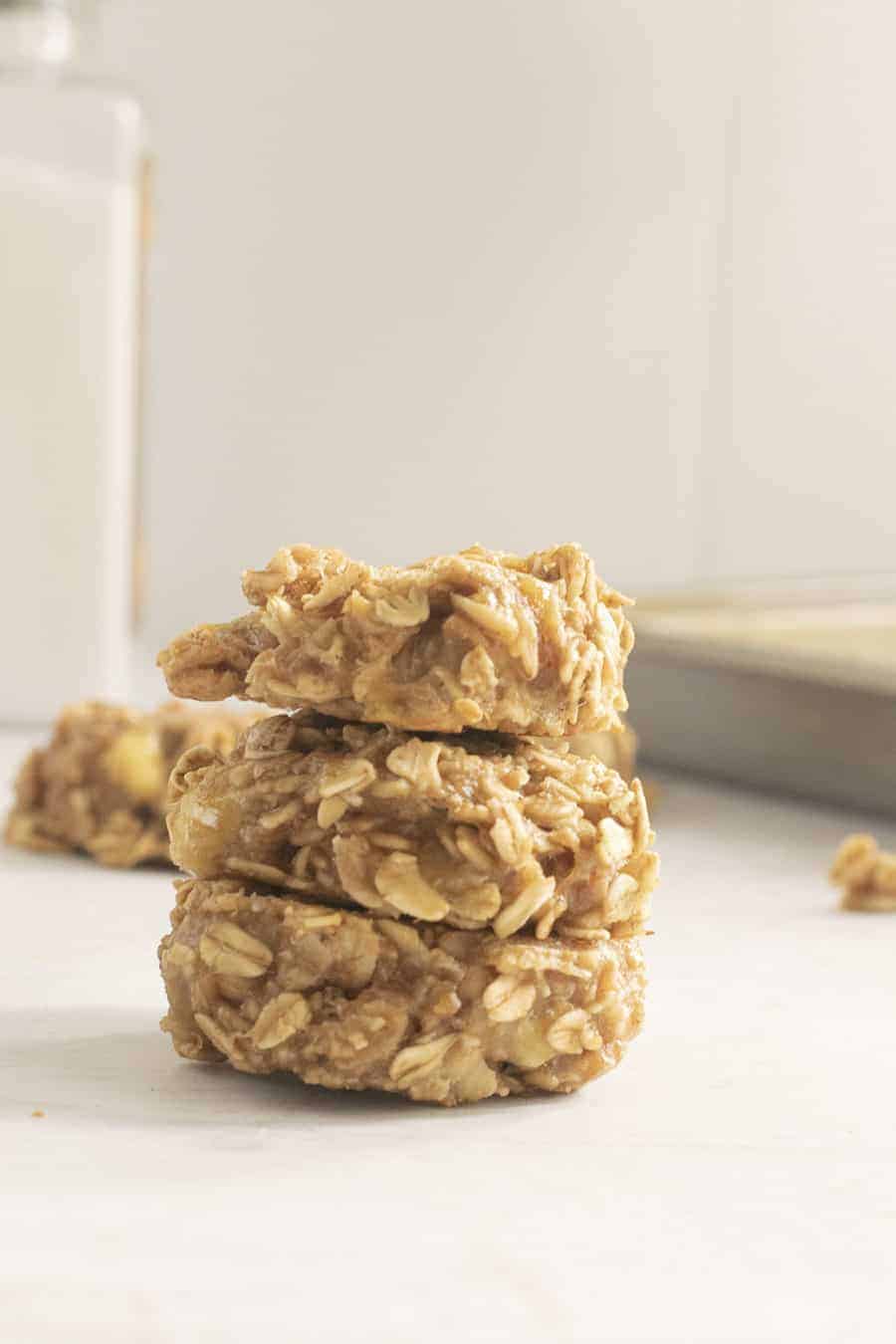 Three oatmeal cookies stacked together with white background.