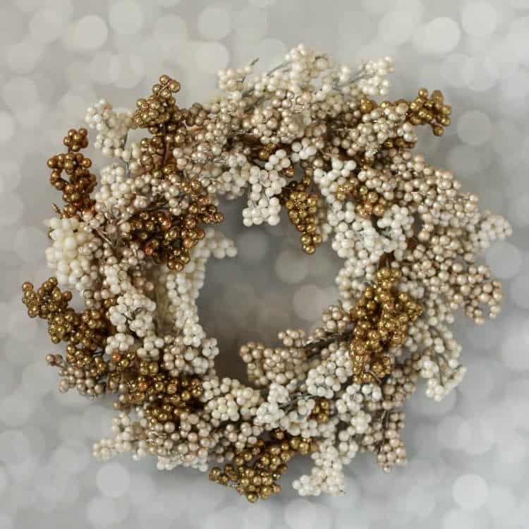 A wreath made from white and gold decorative berries.