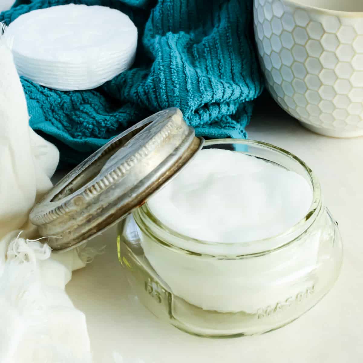 Make up remover pads in a clear jar and on a blue washcloth.