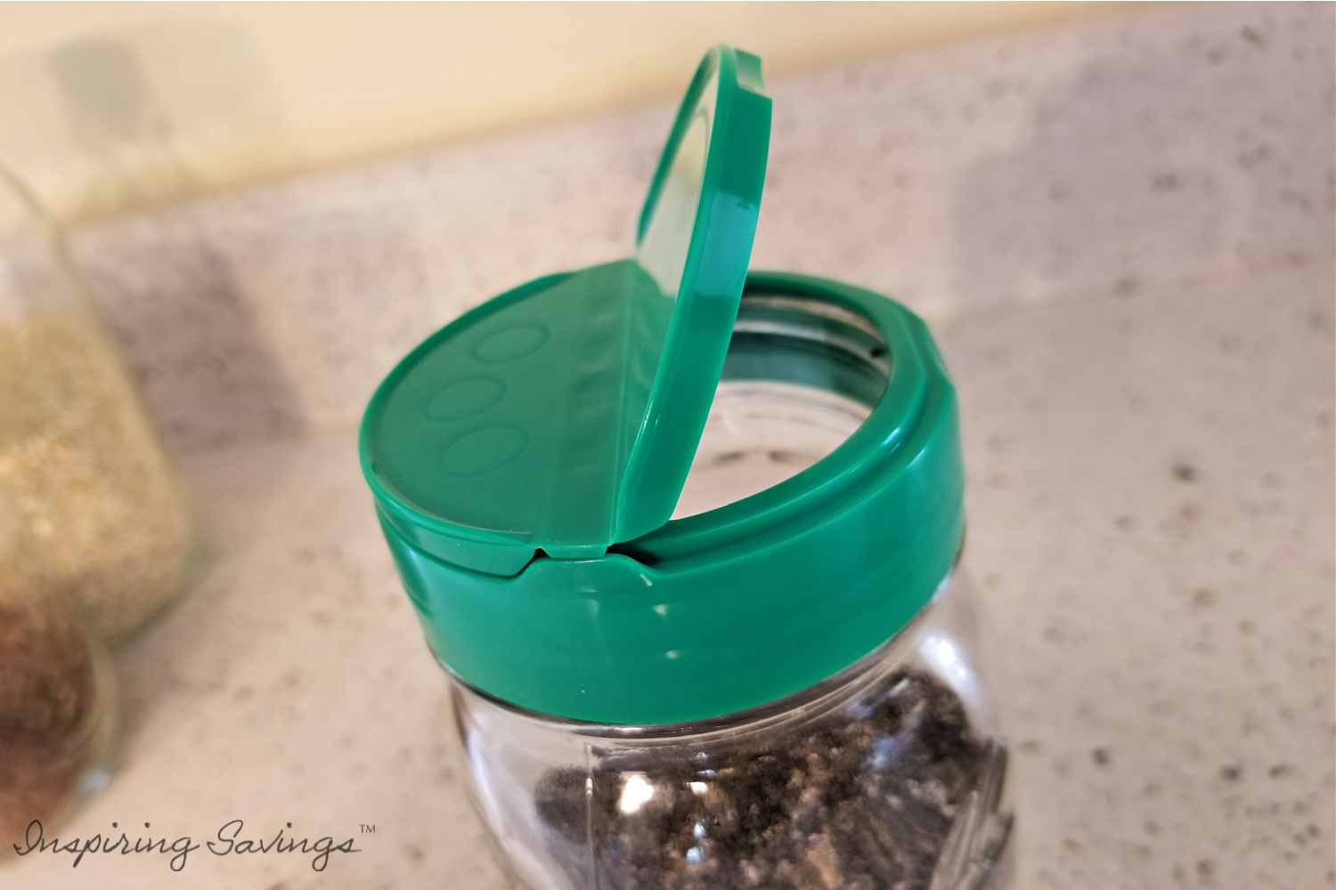 A mason jar with green lid that is half open.