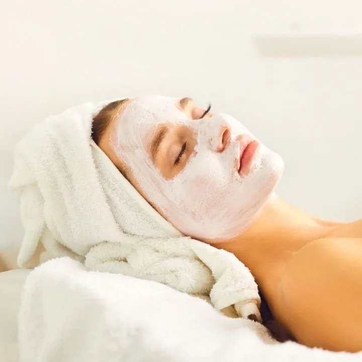 A woman resting with closed eyes and face mask applied to the face.