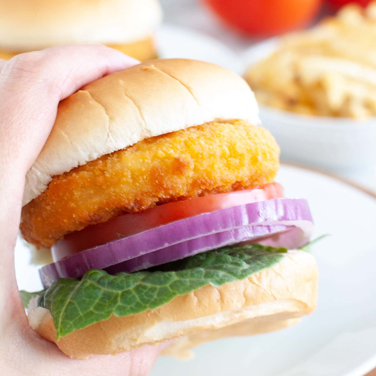 A person holding an air fried chicken patty sandwich.