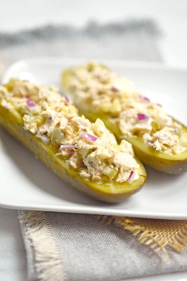 Two pieces of tuna pickle boats on a white plate.