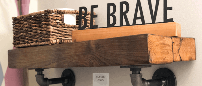 Bathroom shelf with DIY "be brave" wording next to a brown basket.