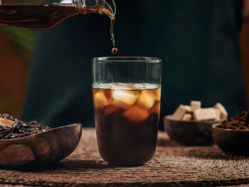 A glass of iced americano with ice cubes.