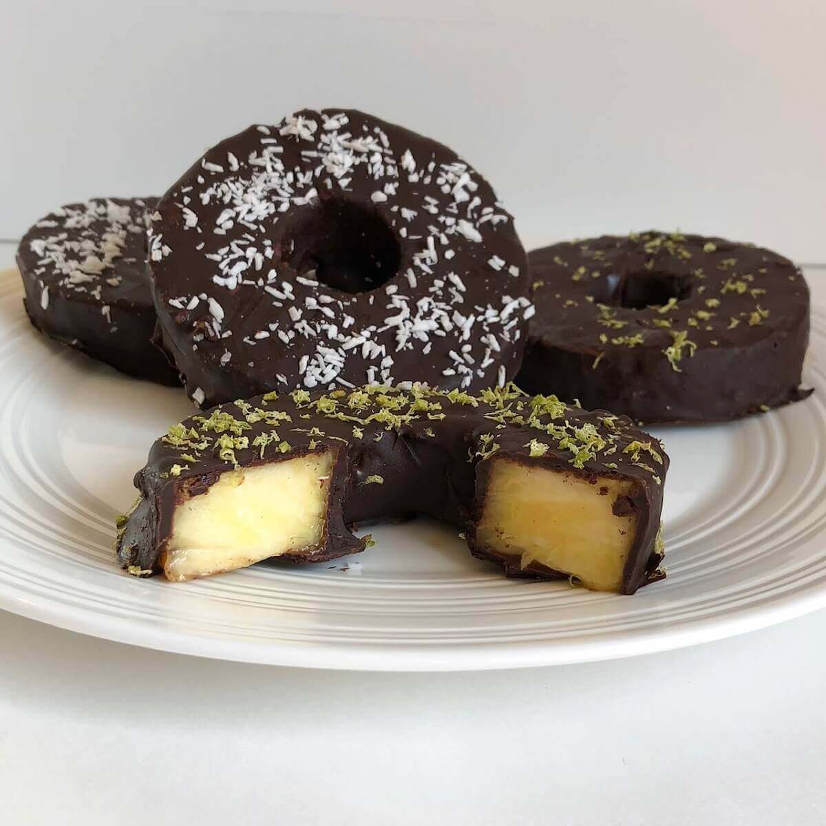 A plate of round pineapple slices covered in chocolate.