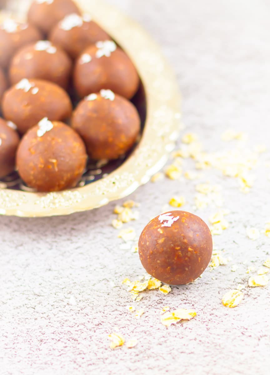 Chocolate peanut butter balls on a plate with one off the plate surrounded by garnish.