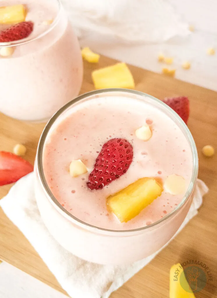 Two glasses of bahama mama smoothie on a chopping board.