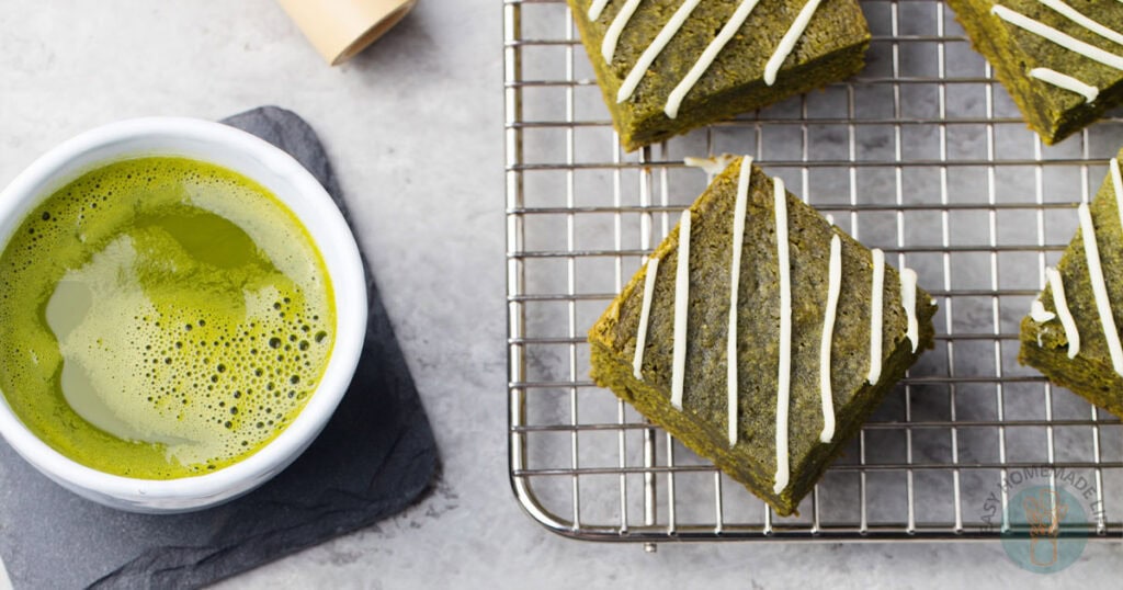 Four square slices of matcha brownies with white chocolate icing.