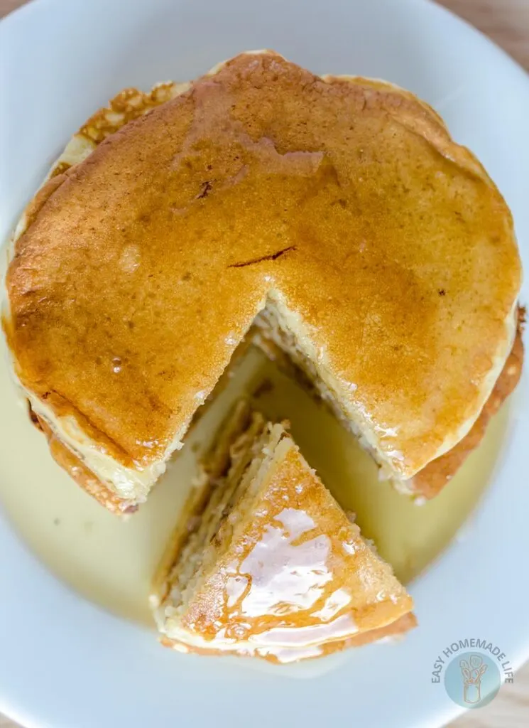 McDonald's pancakes on a white plate with one side cut into a triangle portion.