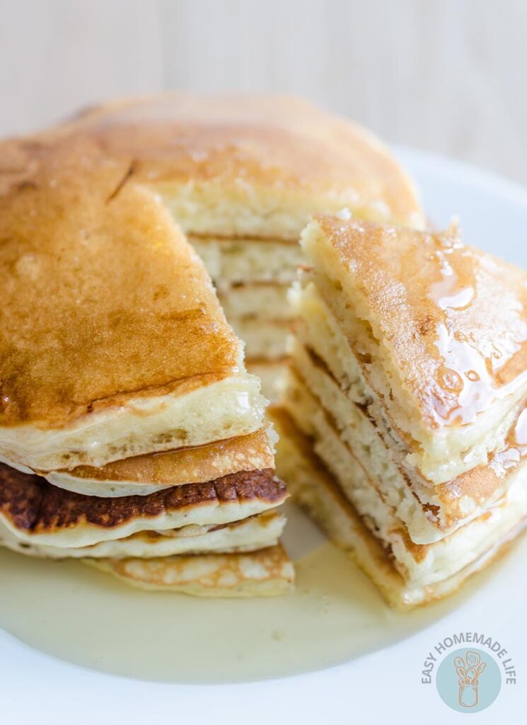 A stack of copycat McDonald's pancakes on a white plate with one side cut into a triangle portion.