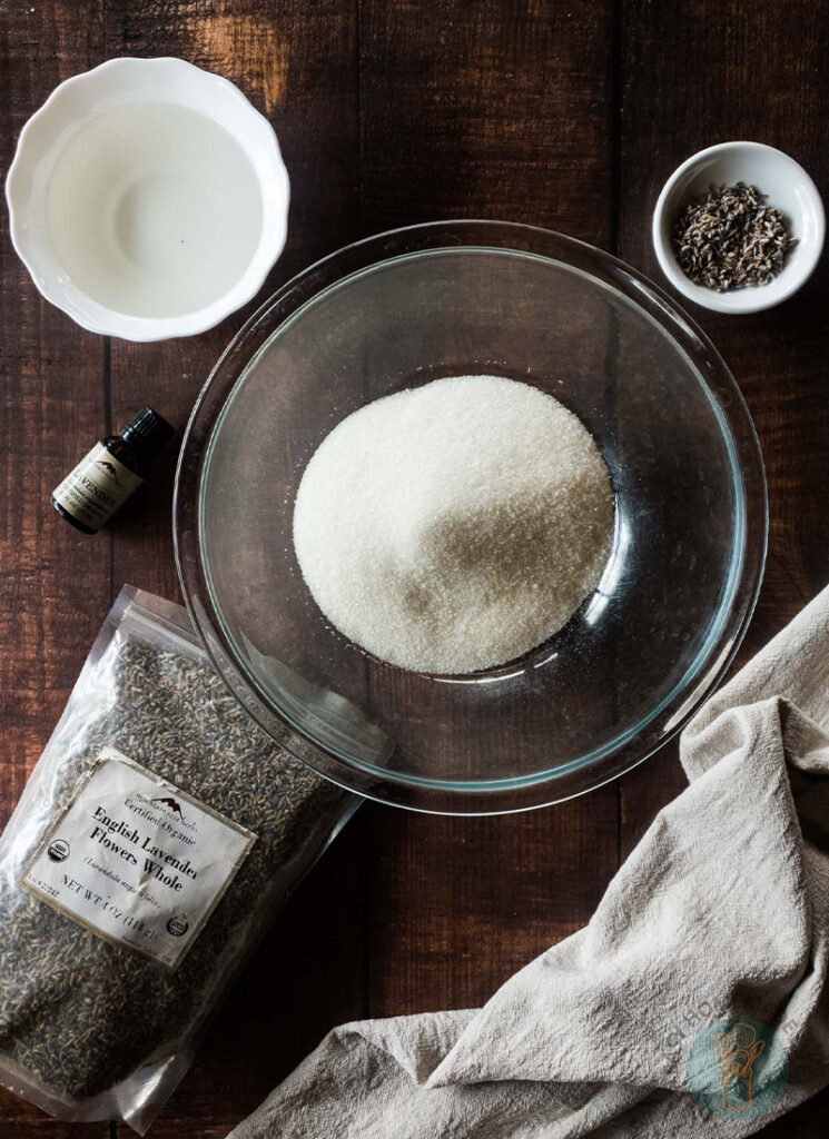 Lavender sugar scrub ingredients in separate bowls and containers.