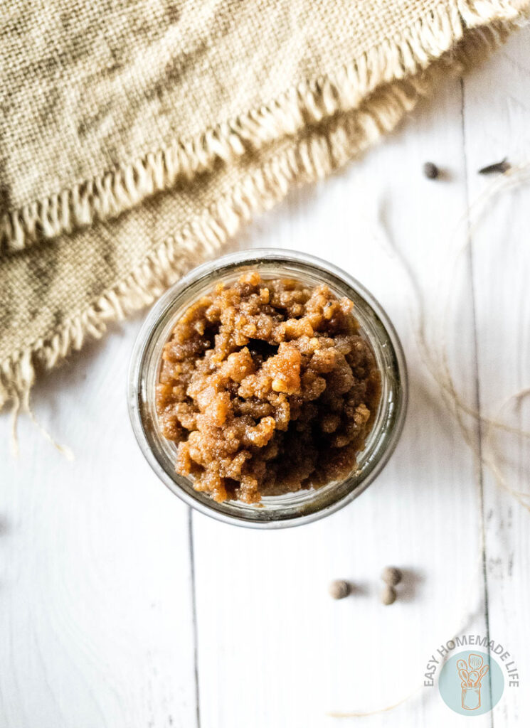 A jar of pumpkin pie spice facial scrub placed on a wooden table.