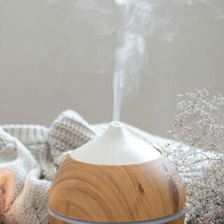 An essential oil diffuser sitting on a wooden table.