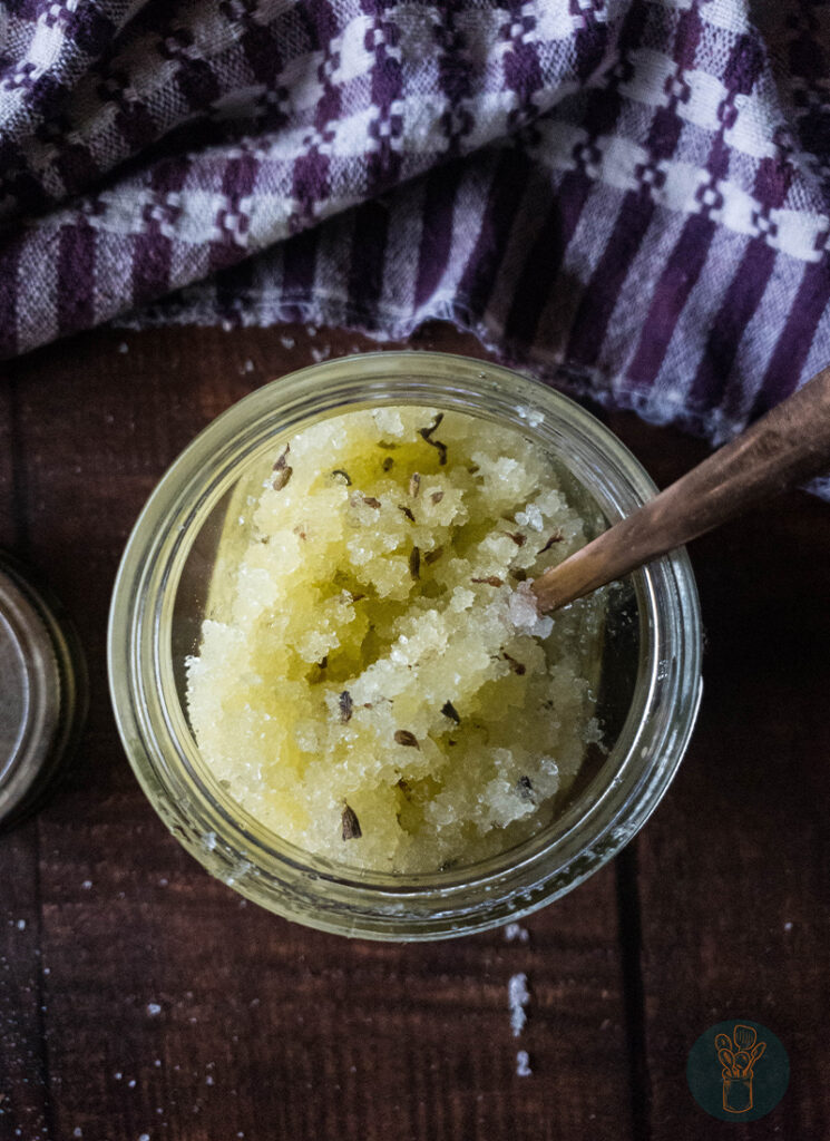 Lavender salt scrub in a jar with a spoon.