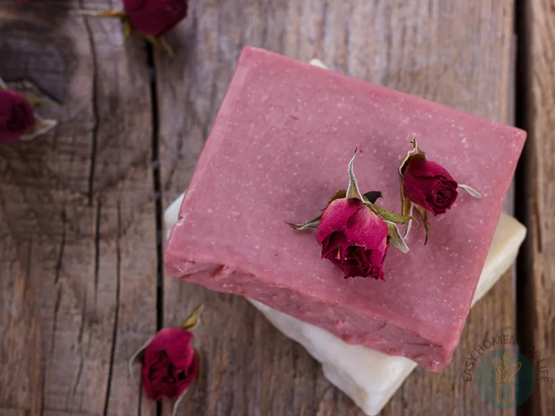 Pink rose soap on a wooden table.