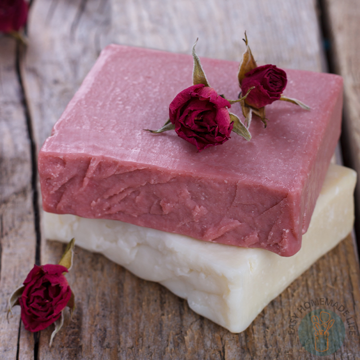 Two pieces of red and white soap with two roses on top.