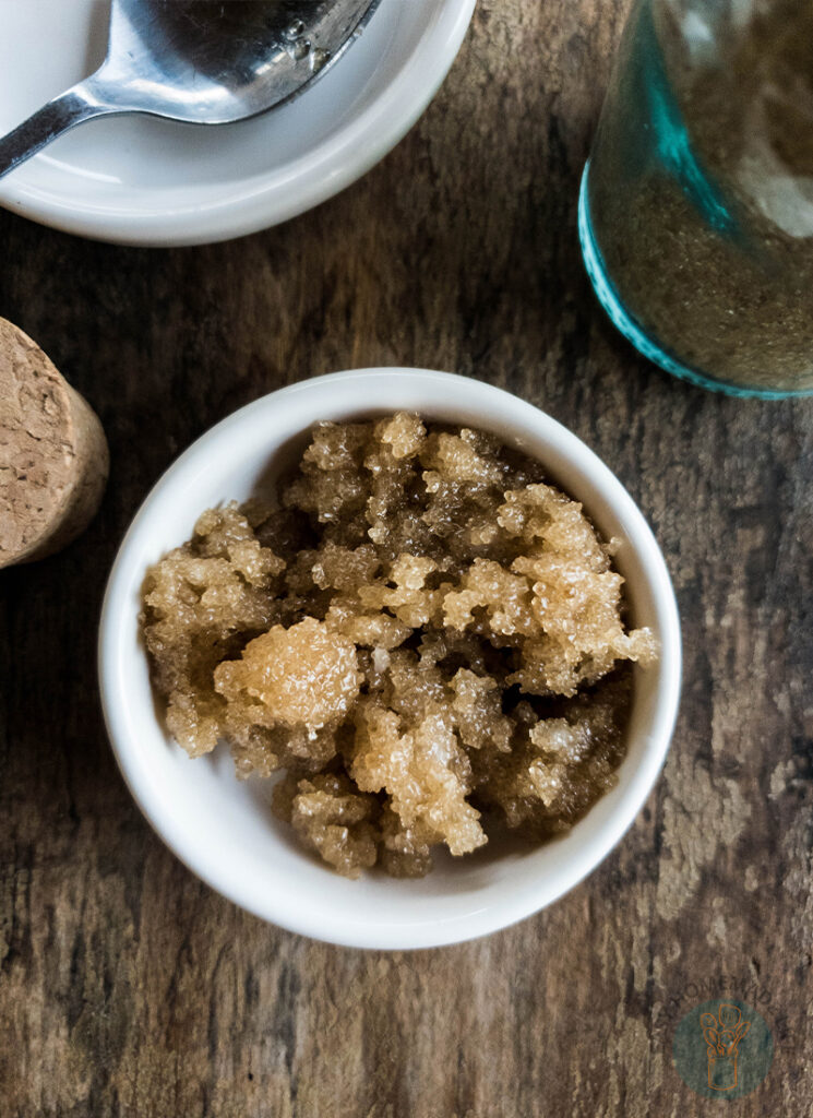 A bowl of brown sugar lip scrub on a wooden table.