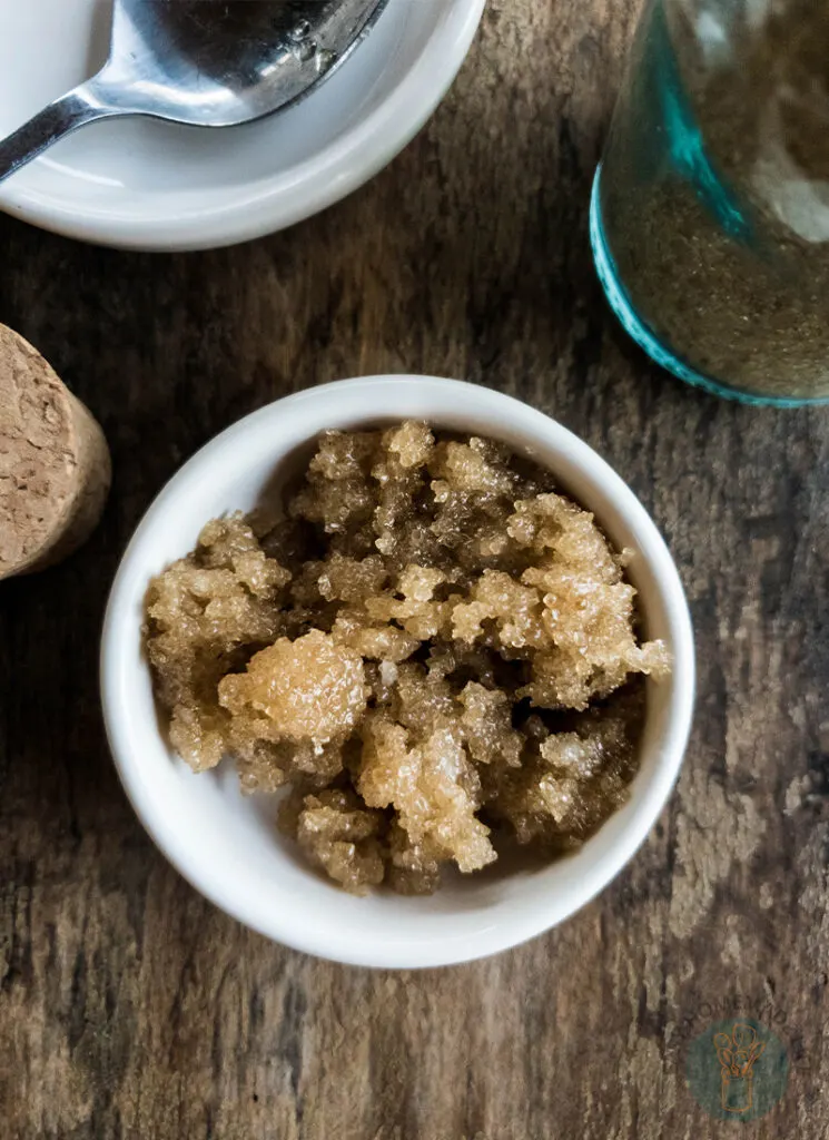 A bowl of brown sugar lip scrub on a wooden table.