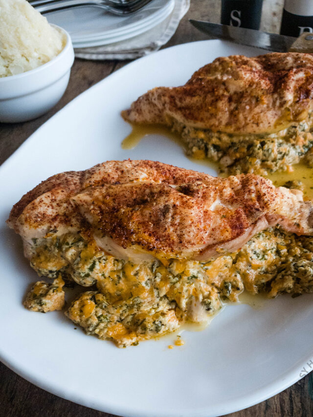Chicken breasts with spinach and cheese on a white plate.