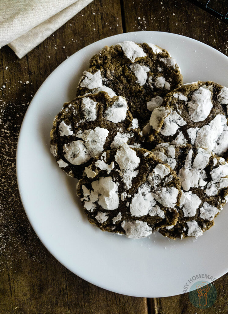 Crinkle chai cookies on a plate with powdered sugar.