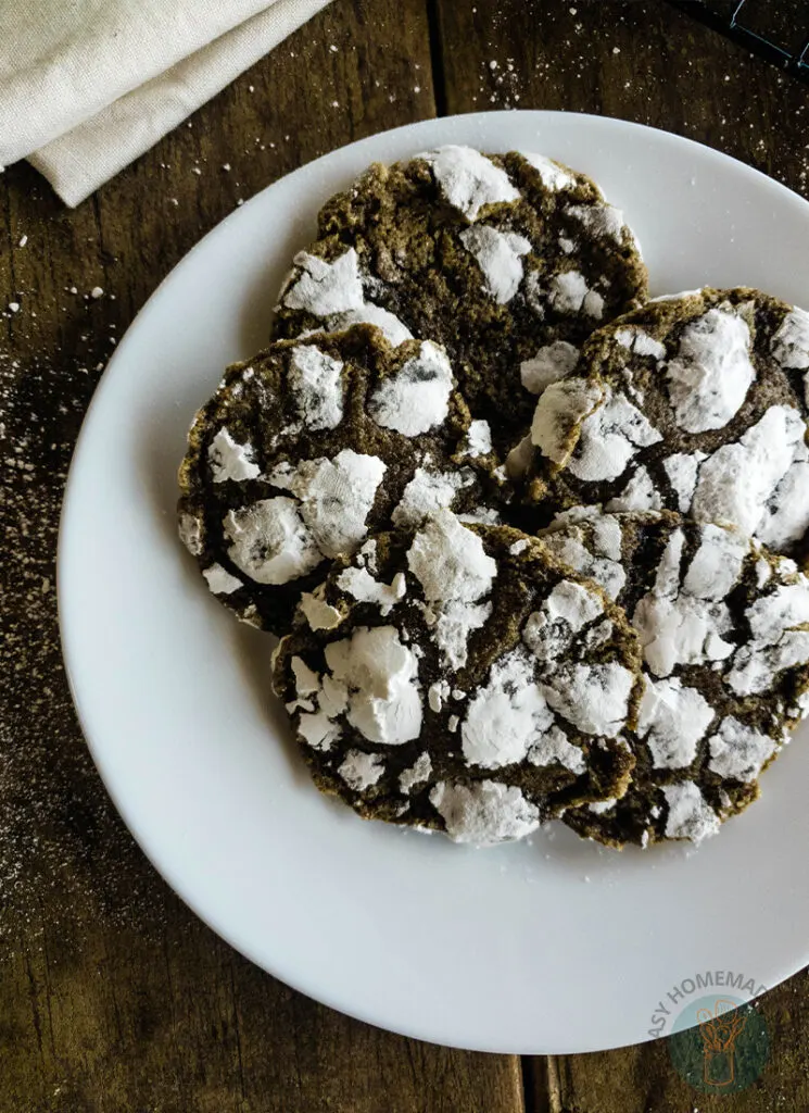 Crinkle chai cookies on a plate with powdered sugar.