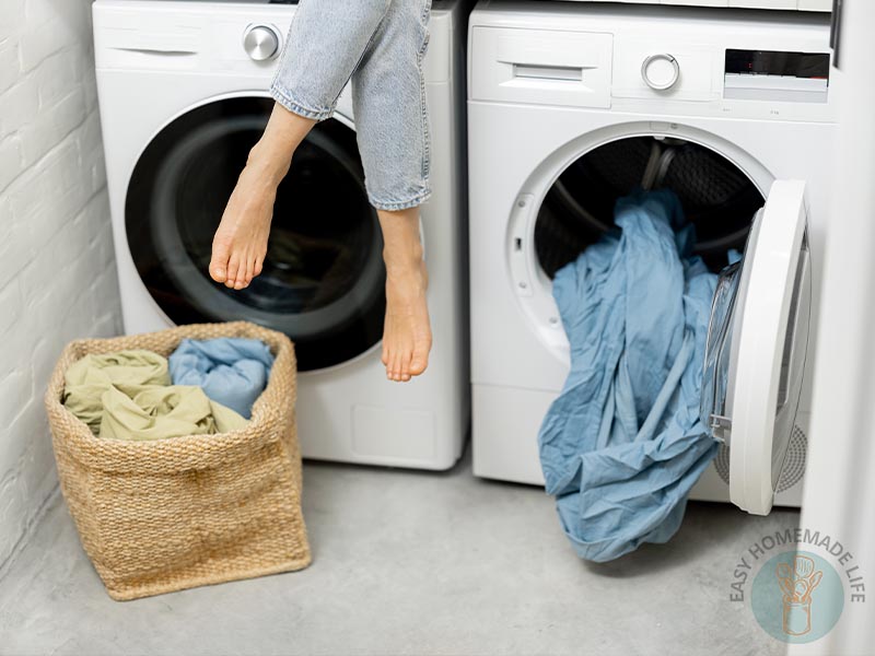 A woman's feet in front of a washing machine.