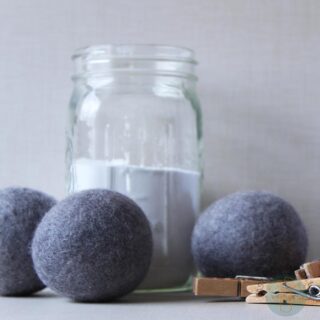 Felt balls next to a jar with clothespins.