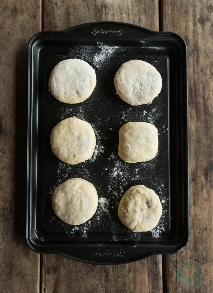 A baking sheet with six biscuits on it.