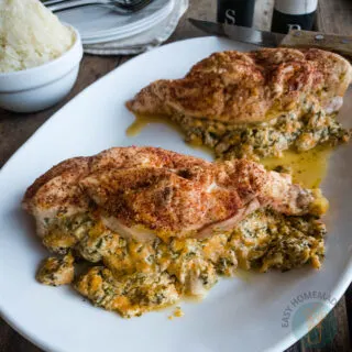 Two stuffed chicken breasts on a white plate.