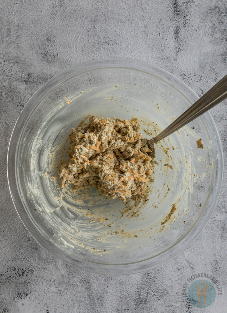 A bowl of mixed ingredients with a spoon in it.