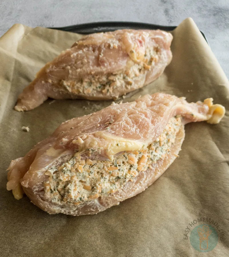 Two stuffed chicken breasts on a baking sheet.
