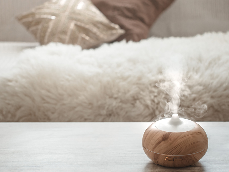 An essential oil diffuser sitting on top of a table near a couch.