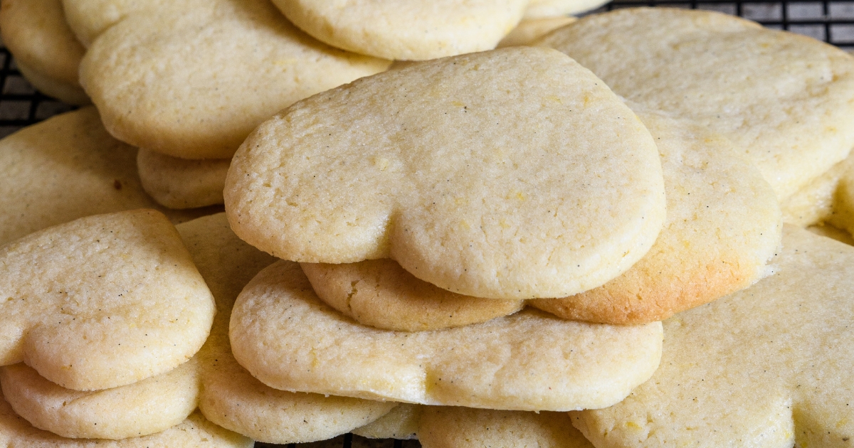 A stack of heart shaped cookies on a cooling rack.